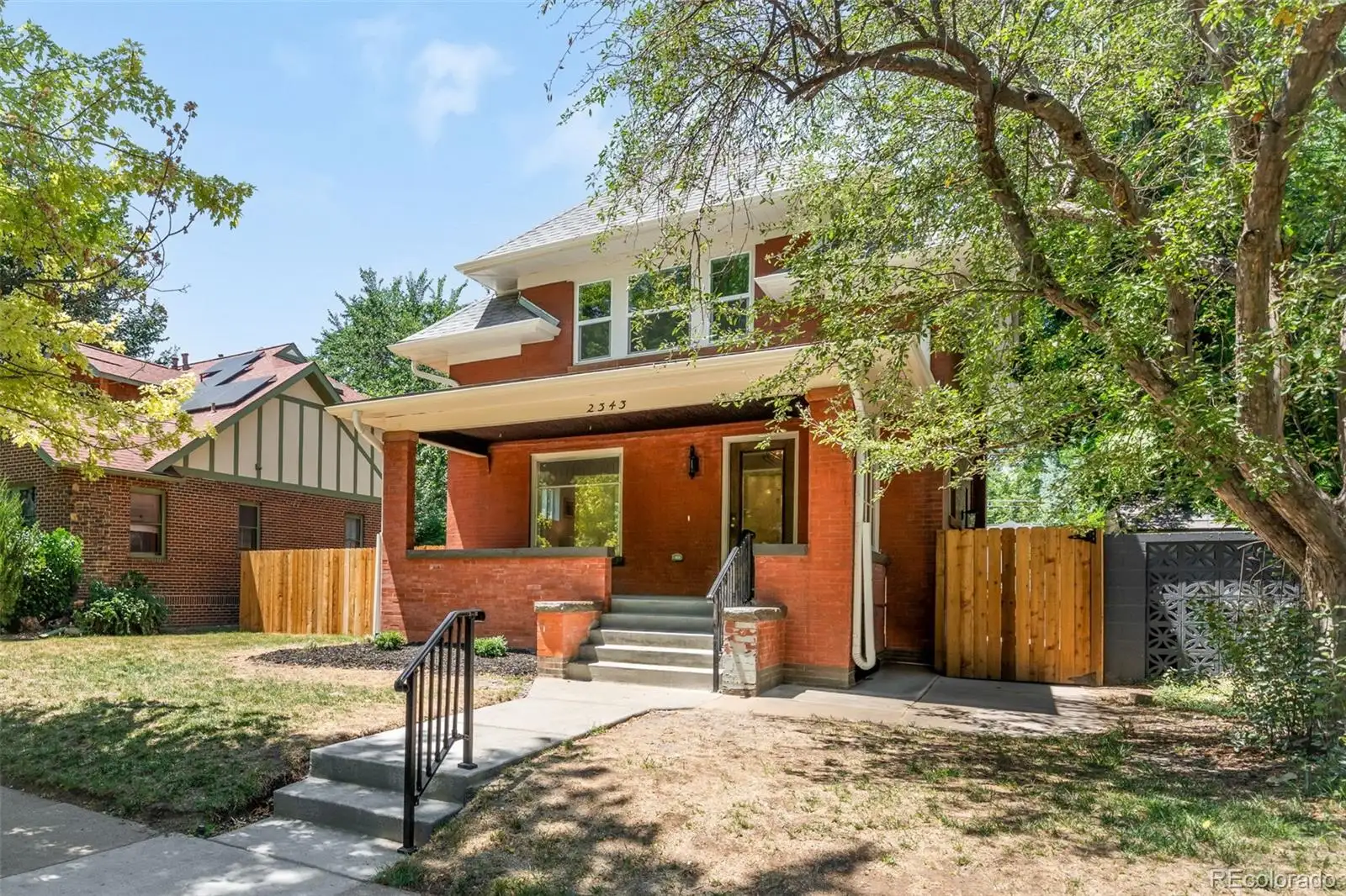 Front exterior: a red-brick Park Hill bungalow with a broad front porch